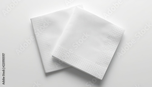 Two clean white paper napkins folded and stacked isolated on white background