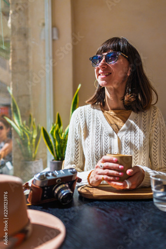 A young girl drinking coffee in a cafe. Beautiful morning.