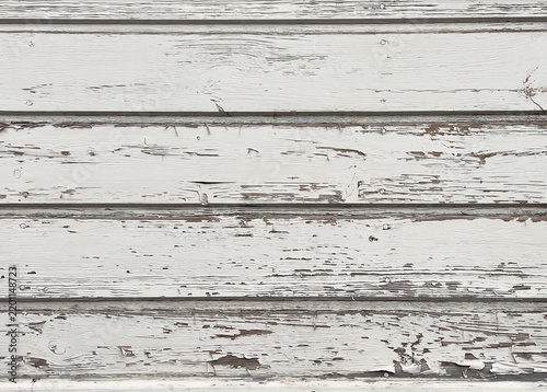 Close-up of horizontal wooden planks with distressed white paint revealing weathered wood grain and natural imperfections.