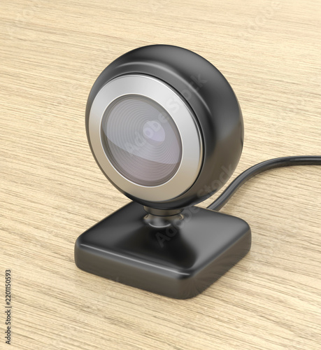 Black webcam or baby monitor on wooden table