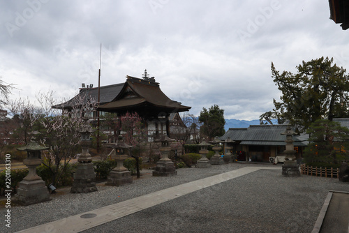 Peaceful view of the Zenko-ji Temple complex with traditional wooden structures and stone lanterns in Nagano