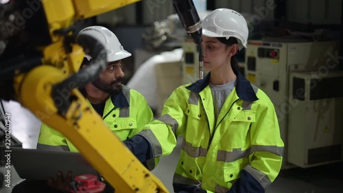 Industrial engineers collaborating on robotic arm automation