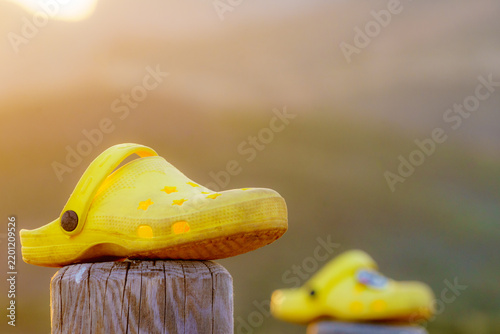 Obraz na plátně Shoes clogs outdoors against sunset light