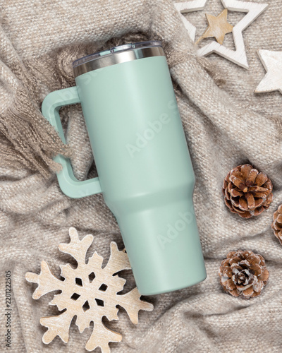Light green tumbler mockup, blank stainless steel cup on beige blanket, Christmas rustic scene