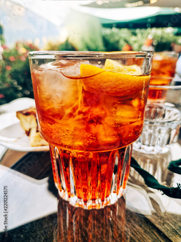 Typical Italian cocktail called spritz served in a glass tumbler resting on a table