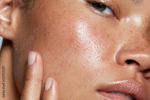 Close-up view of a person touching their face highlighting skin texture and beauty. National Healthy Skin Month