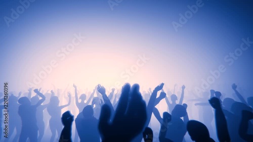 Energetic crowd enjoying a music concert with hands in the air and bright stage lights.