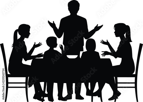 Silhouette of a happy family eating dinner together at the kitchen table