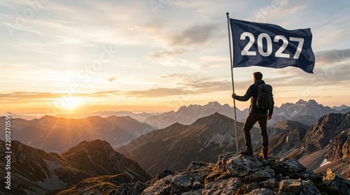 Hiker holding flag with year 2027 on mountain peak at sunset