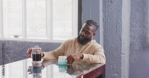 Businessman enjoying coffee break at office, sitting at table with French press
