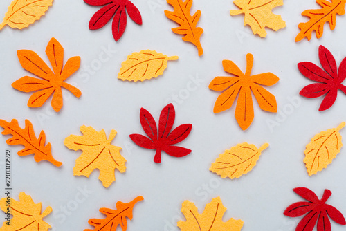Small decorative autumn leaves on color background, top view