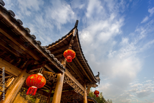 Chinese culture and travel, traditional wooden architecture with red lanterns under blue sky