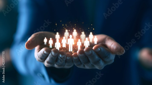 Professional business person holding glowing human icons to represent corporate human resources management strategy in a dark modern office setting