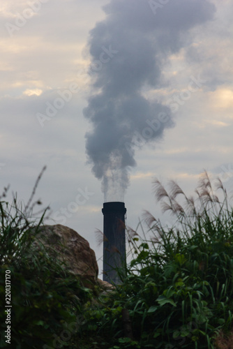 Climate change and air pollution, industrial smoke stack emitting carbon emissions into the sky