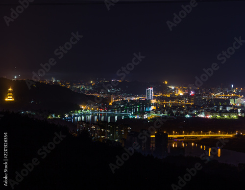 Urban development and city skyline at night, glowing lights in a modern metropolitan landscape