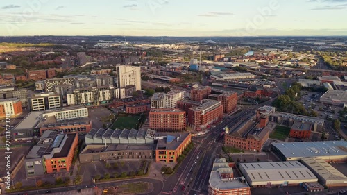 Ambient drone exploration of Leeds, West Yorkshire, England, United Kingdom. Aerial POV of Central City infrastructure, skyscrapers, old town buildings, river and transport in sunset, golden hour.
