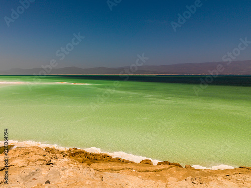 Turquoise water gradually deepens to dark blue beneath a hazy mountain horizon, Dikhil Region, Lake Assal, Djibouti