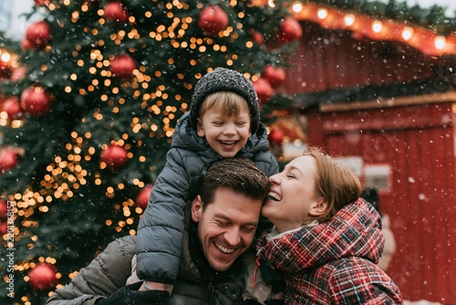 Happy family with children at Christmas market in falling snow