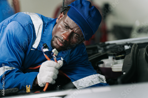 Electric Vehicle Mechanic Inspecting Motor During Professional Repair.