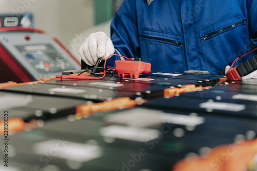 Technician Inspecting Electric Vehicle Battery Pack Components.