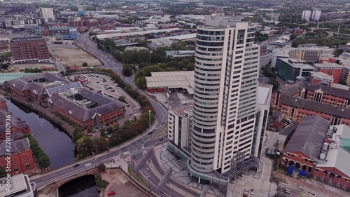 Ambient drone exploration of Leeds, West Yorkshire, England, United Kingdom. Aerial POV of Central City infrastructure, skyscrapers, old town buildings, river and transport in sunset, golden hour.