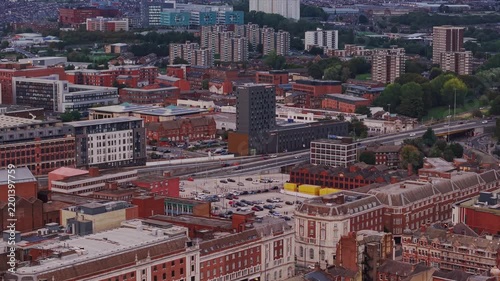 Ambient drone exploration of Leeds, West Yorkshire, England, United Kingdom. Aerial POV of Central City infrastructure, skyscrapers, old town buildings, river and transport in sunset, golden hour.