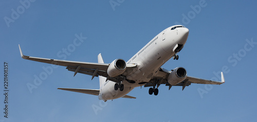 The plane lands. Airplane, passengers flying in the blue sky, preparing to land at the airport