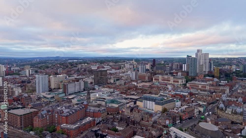 Ambient drone exploration of Leeds, West Yorkshire, England, United Kingdom. Aerial POV of Central City infrastructure, skyscrapers, old town buildings, river and transport in sunset, golden hour.
