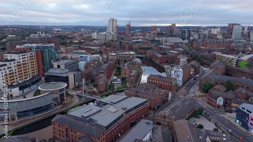 Ambient drone exploration of Leeds, West Yorkshire, England, United Kingdom. Aerial POV of Central City infrastructure, skyscrapers, old town buildings, river and transport in sunset, golden hour.