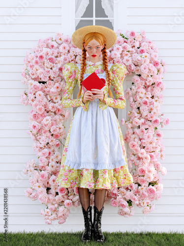 Young woman in floral dress holding a red book in front of a pink flower backdrop