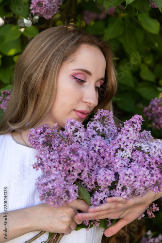 Dreamy springtime portrait with lilac flowers and feminine beauty concept