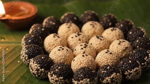 Traditional til ladoo offering with diya and banana leaf for pitru paksha ritual during durga puja navratri and hindu ancestral worship ceremony