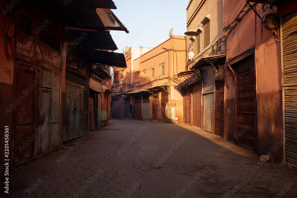 Fototapeta premium Moroccan market alleyway in old city street under warm sunlight