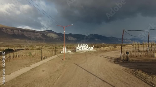4K drone aerial view over Lago Posadas village in Santa Cruz, Argentina, revealing homes surrounded by rugged Patagonian landscapes, arid terrain and remote wilderness scenery.