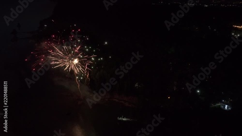 Drone view of festive fireworks in the dark night sky, colorful firecrackers bursting in the air. The spirit of universal merriment and New Year holidays.
