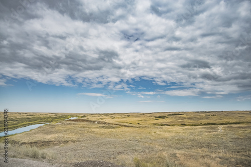 Obraz na plátně Steppe river flowing through the wild steppes of Kazakhstan in summer under clou