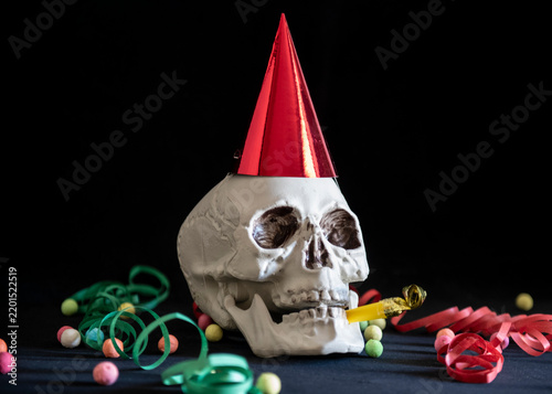 Skull celebrating birthday with party hat and horn