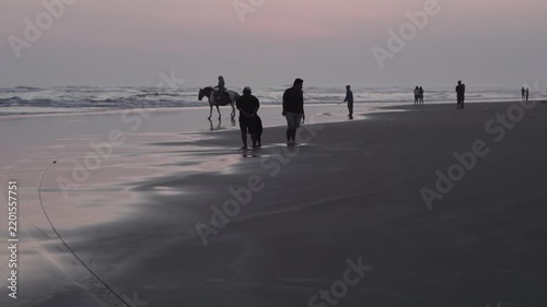 Silhouette of People and Horse at Parang Tritis Beach, Yogyakarta at Sunset