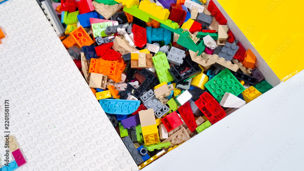 Obraz premium Huge pile of colorful unsorted lego plastic building blocks and toy bricks inside storage tray with white baseplate in play area on September 22, 2026 in Bangkok, Thailand.