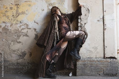 Bild auf Leinwand Exhausted woman leaning back on crumbling wall, head thrown back, fatigue and hi
