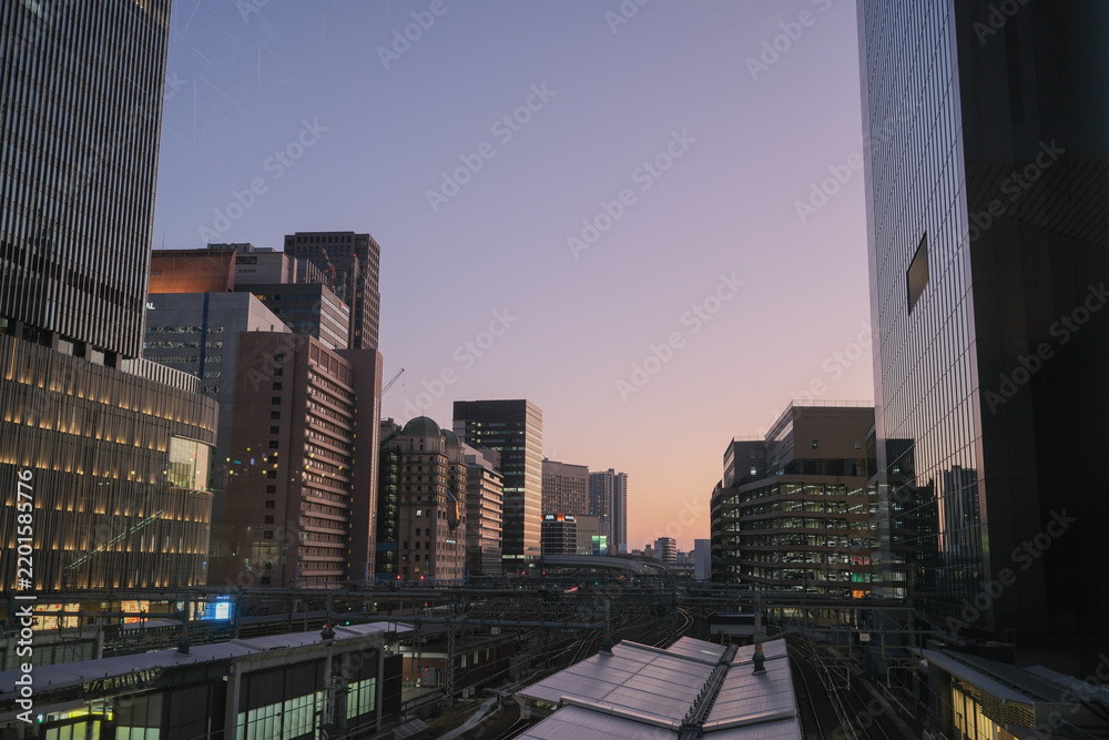 Obraz premium Osaka city skyline at dusk with modern buildings and railway tracks, Japan