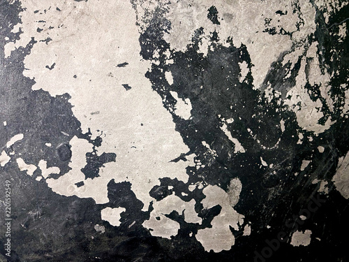 Peeling paint texture on dark concrete surface showing abstract organic shapes.