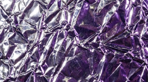 Crumpled purple metallic foil texture background.