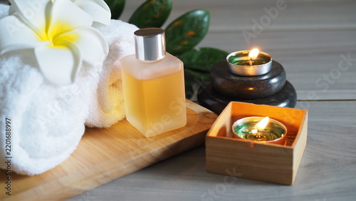 Foto Spa and wellness set arranged on a wooden tray, consisting of rolled-up white towels and decorated with white frangipani flowers