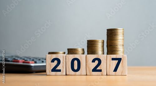 2027 financial growth and investment concept with stacked coins on wooden blocks and calculator