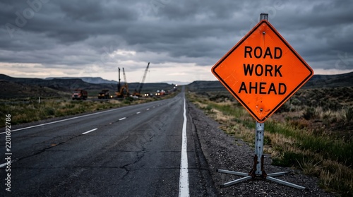 Road work ahead sign on a highway during a gloomy cloudy day