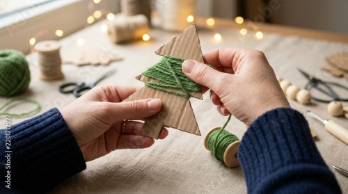 Hands Crafting DIY Eco Friendly Christmas Tree Ornament With Recycled Cardboard And Green Yarn For Holiday Decoration
