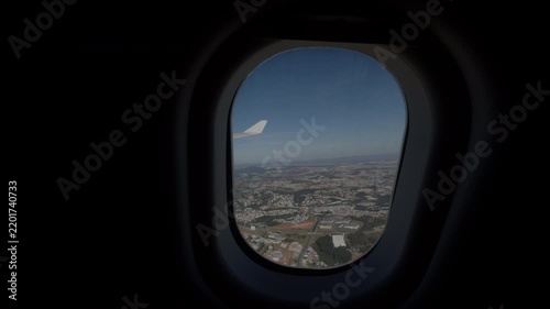 Airplane Wing Seen Through Window Above Expansive City Landscape