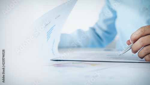 Businessman reviewing business financial reports and charts on desk with copy space, concept of data analysis, accounting, business planning, and corporate performance review.
