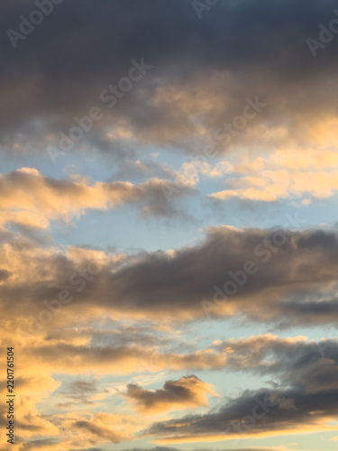 Dramatic Storm Clouds Glowing in Golden Sunset Light Over Blue Sky